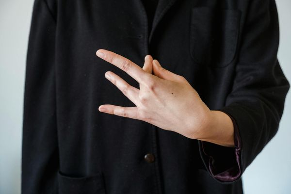 Close up of hands in a mudra position with soft lighting.